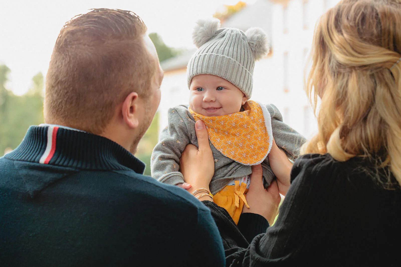 Parents avec leur bébé souriant lors d'une séance photo famille au parc de l'Orangerie à Strasbourg - Photographe naissance Alsace