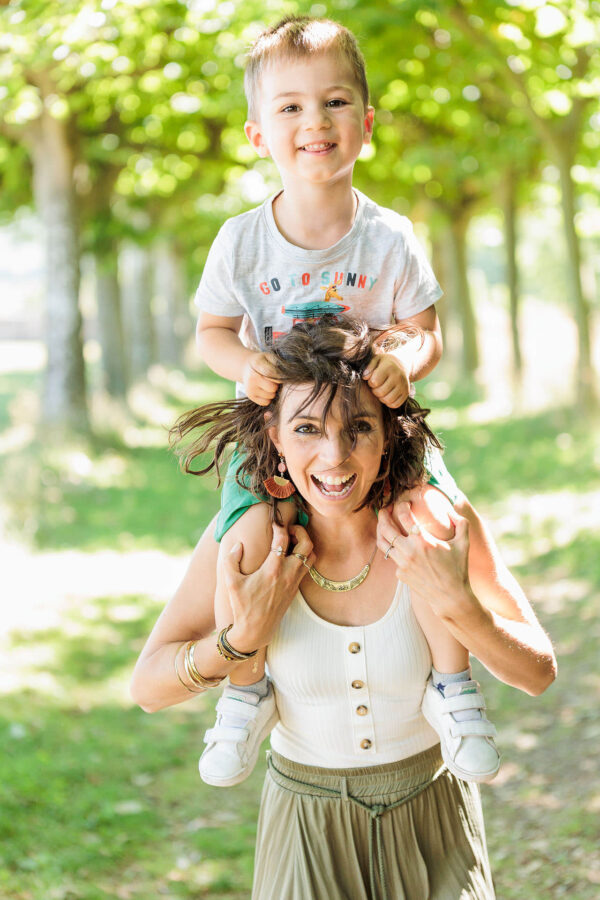Maman portant son fils sur ses épaules lors d'une séance photo Maman et Moi au parc Leonardsau - Photographe famille Obernai