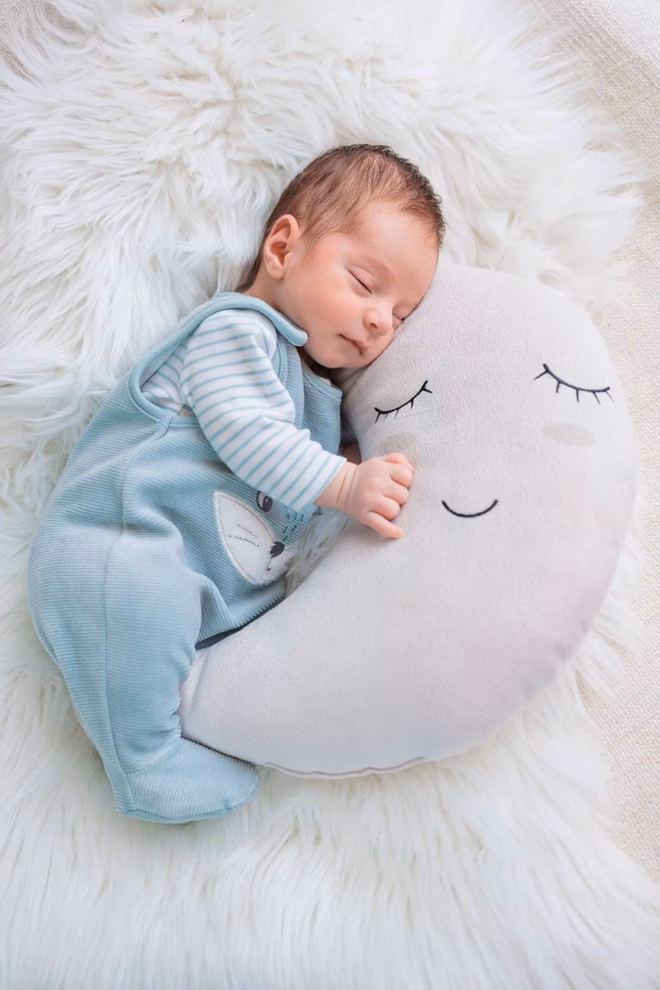 Séance photo naissance — nouveau-né endormi sur coussin