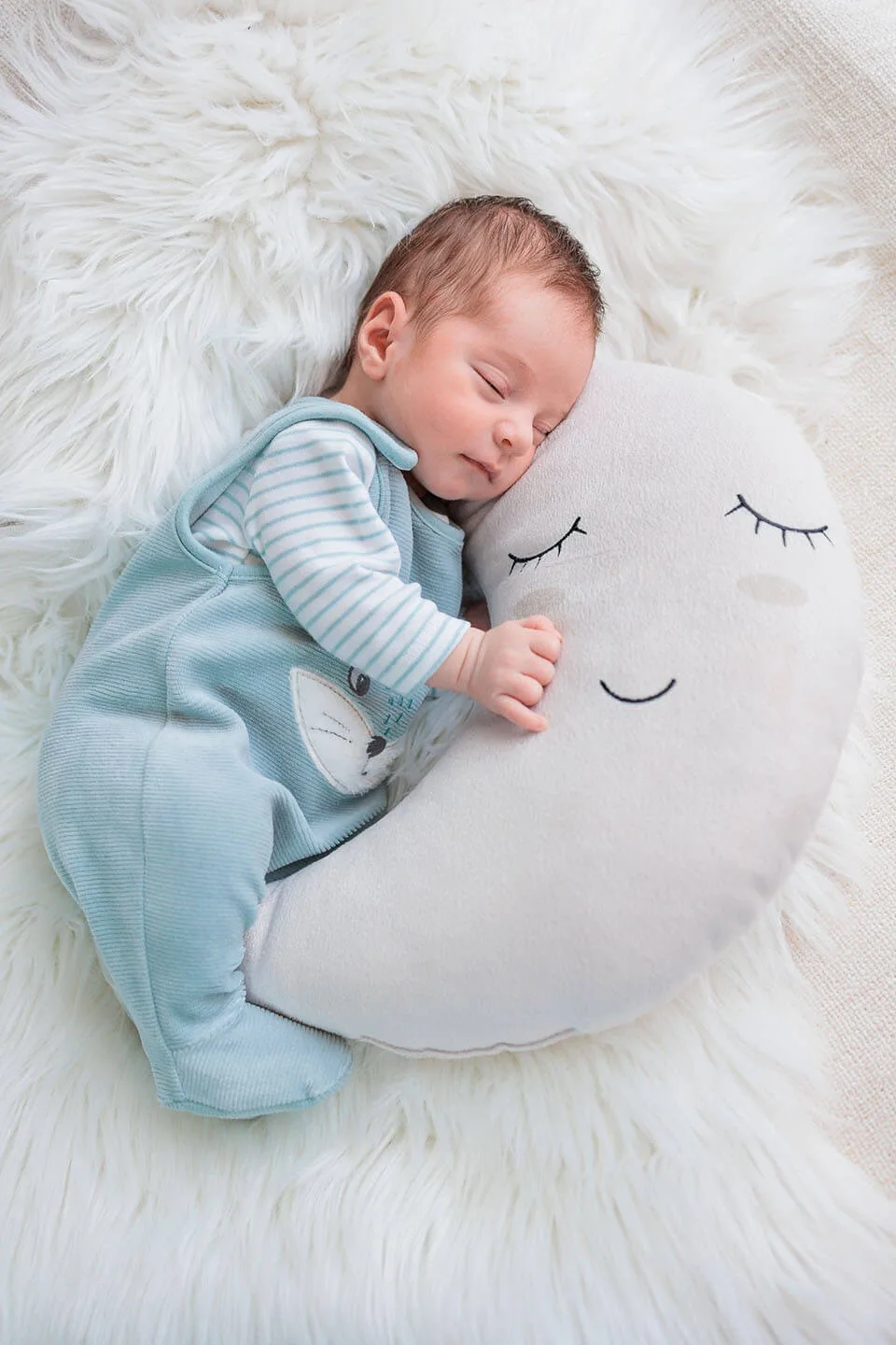 Séance photo naissance — nouveau-né endormi sur coussin