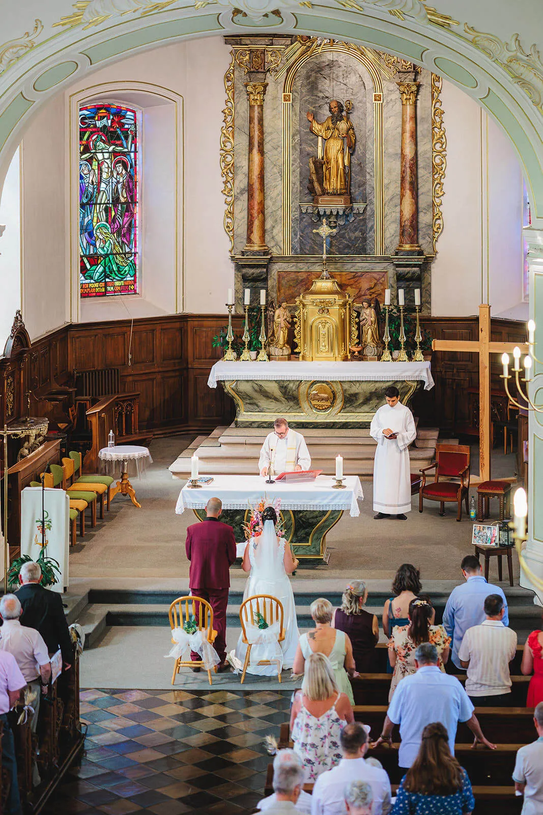 Vue large de la cérémonie de mariage à l'intérieur d'une église ornée
